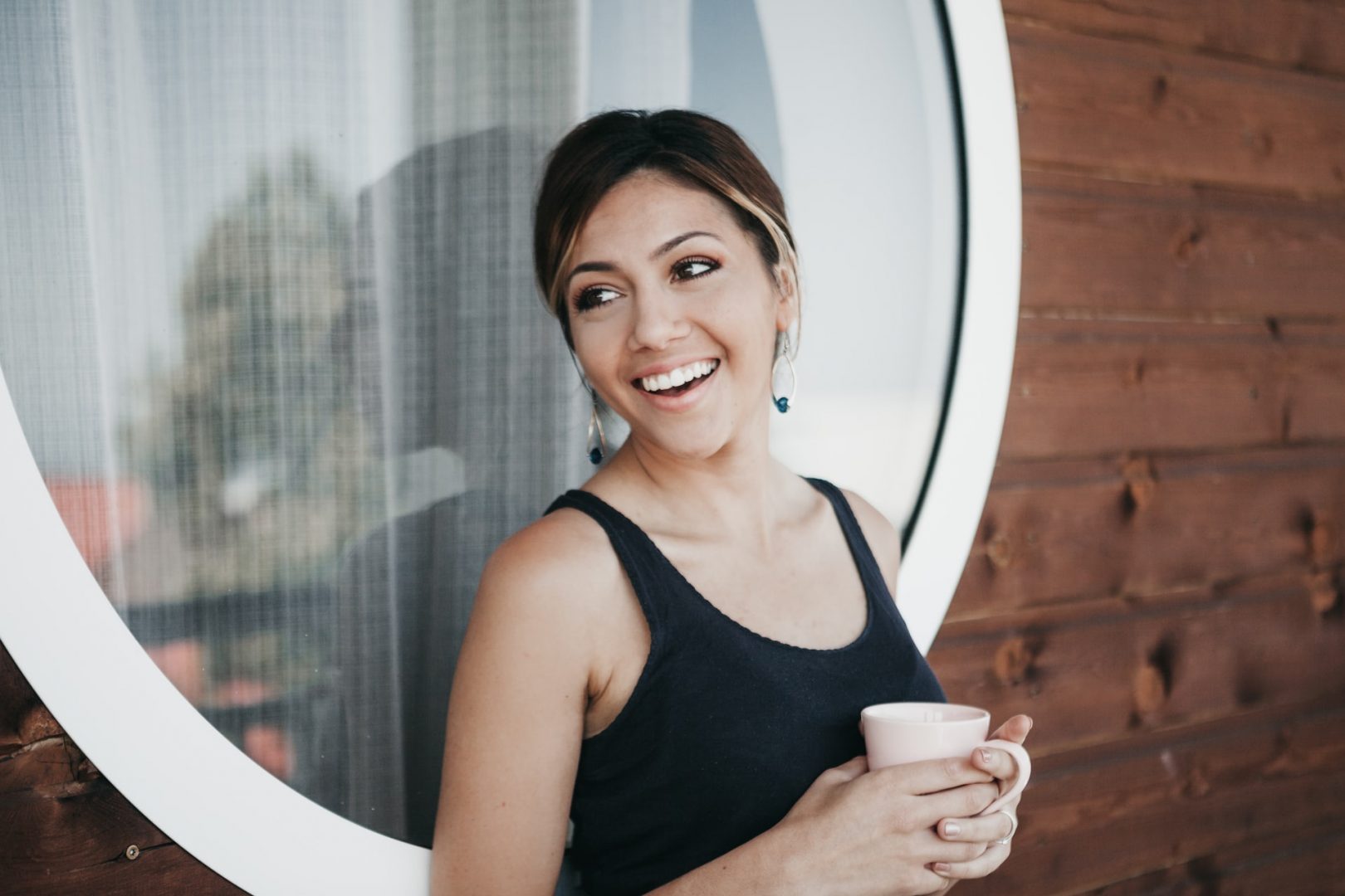 how does weed affect you emotionally happy woman holding coffee in front of window